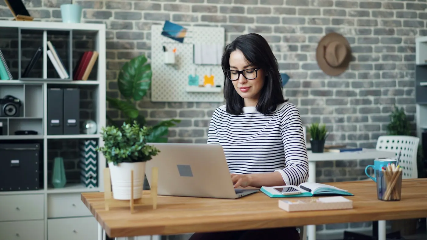 Pessoa em videochamada no notebook em um escritório em casa